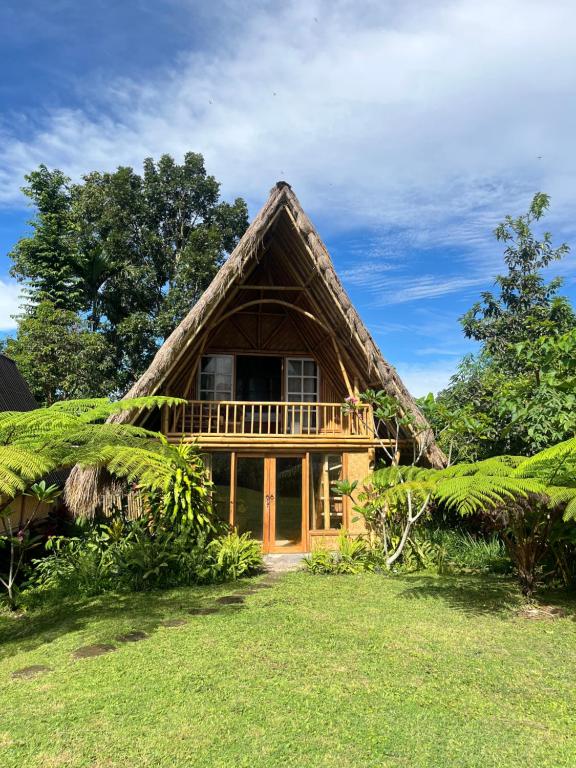 a thatch roofed house with a thatched roof at Girang Rinjani Bungalows in Tetebatu