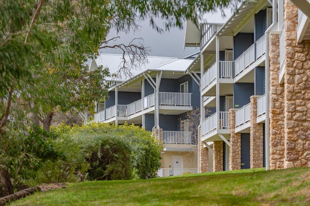 an apartment building with balconies and trees at Caves House Apartments Yallingup in Yallingup