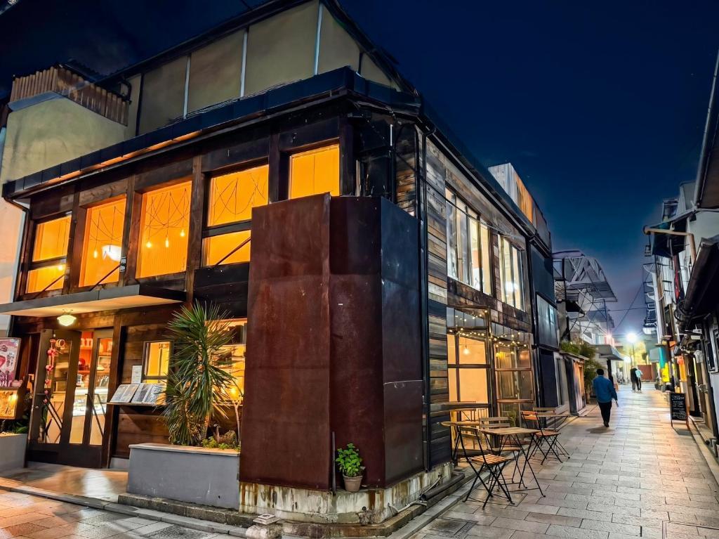a building with large windows on a street at night at LIVE HEART House in Nara