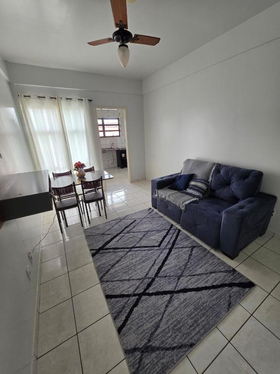 a living room with a blue couch and a table at Apto Confortável com Ar e Cozinha Equipada in Balsas