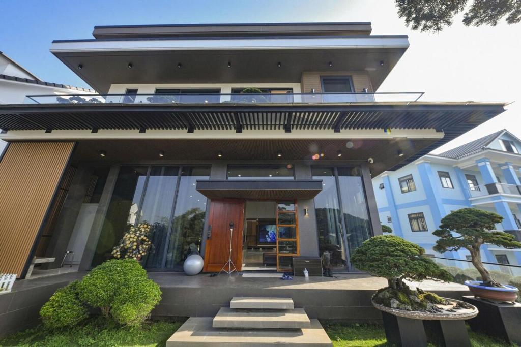 a building with a front entrance with trees in front at La Lapine Villa -6rooms-15Pax in Khu Chi Lăng