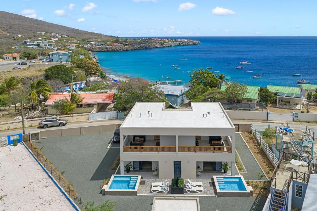 a white house with a view of the ocean at Villa Anosia Laman i Tera in Westpunt