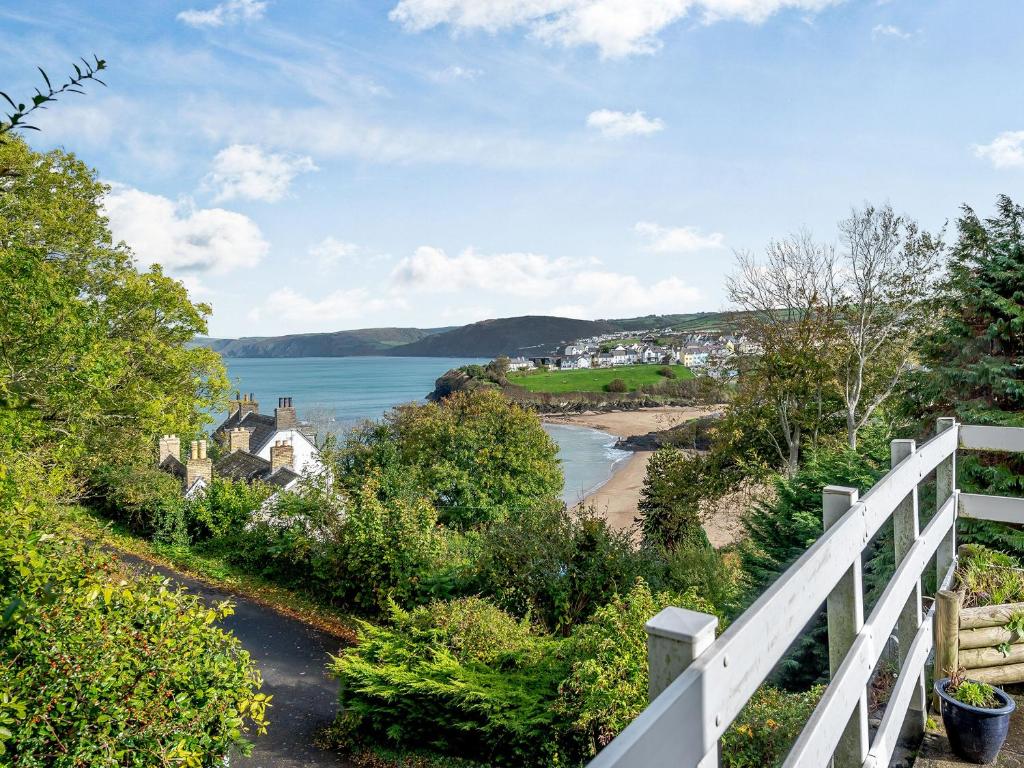 a view of a beach with a white fence at Five Bays View in Aberporth