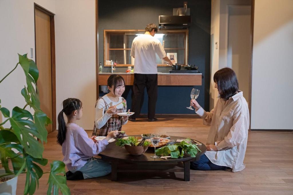a group of people sitting around a table eating food at goemon-inn in Akita