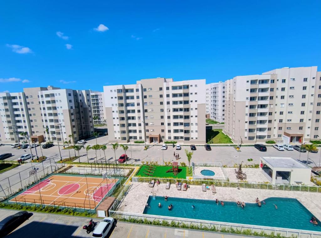 an apartment complex with a pool and a basketball court at Apto com ar e piscina próximo a Cabo Frio e Arraial do Cabo in São Pedro da Aldeia