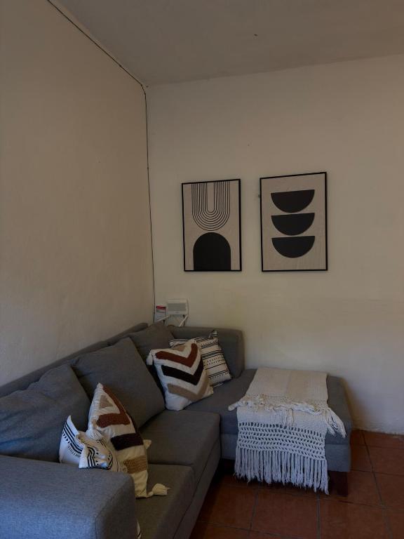 a living room with a couch with pillows on it at Departamento completo casarosa in Valladolid