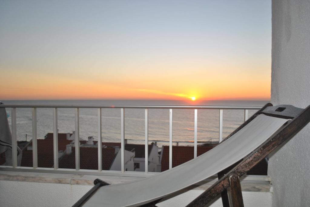 エリセイラにあるEriceira Surf Studioの日没時に海を見渡すバルコニーのスライド