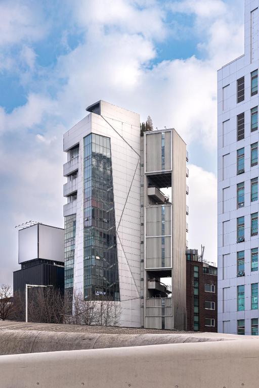 a tall building with glass windows in a city at LAHA Boutique DDP Dongdaemun in Seoul
