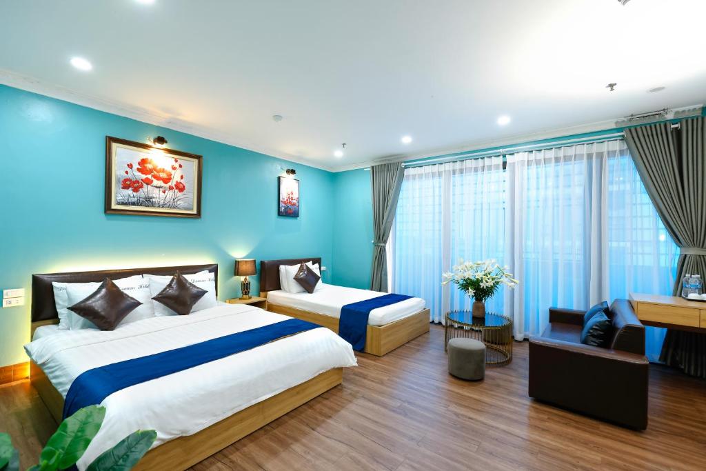 a bedroom with two beds and a blue wall at Dream Hotel Hà Nội in Hanoi