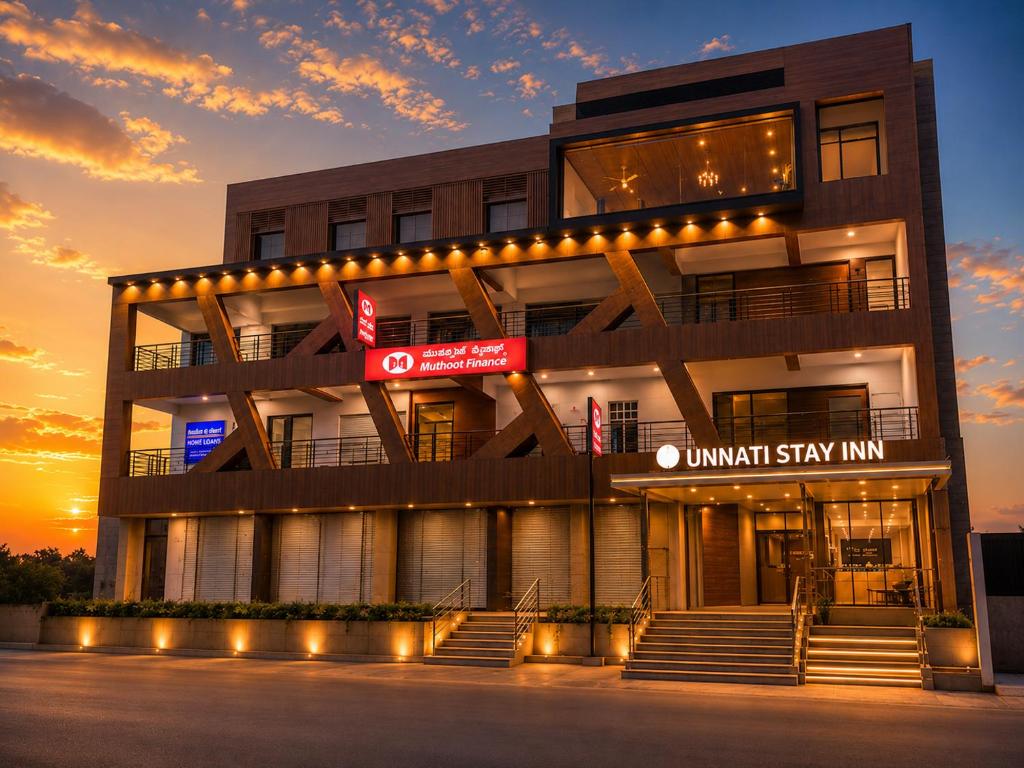 a building with a sign in front of it at Hotel Unnati Stay Inn Vijayapura By HRG in Bijāpur