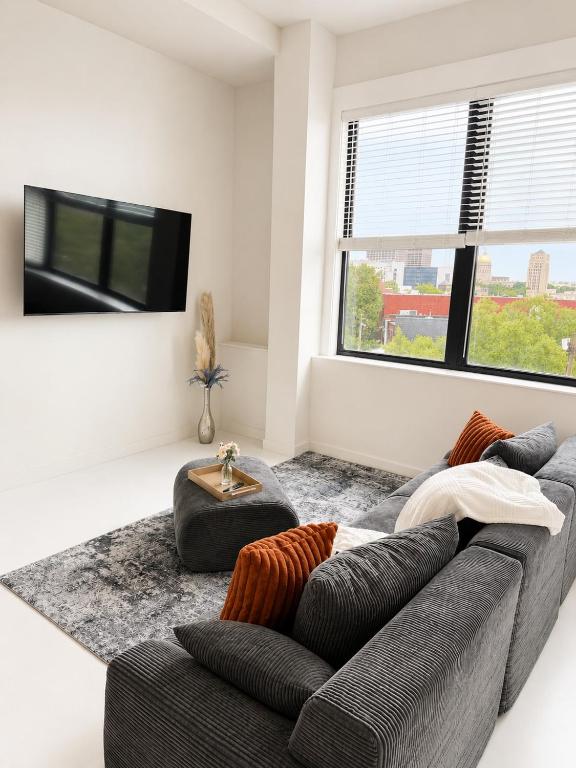 a living room with a couch and a tv at Sapphire Loft Midtown in Atlanta
