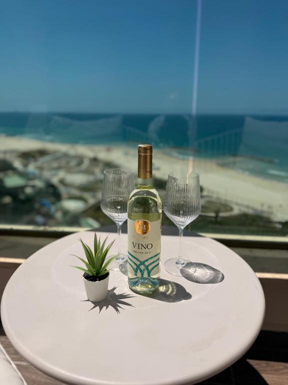 a bottle of wine and two wine glasses on a table at Sunset Suite sea&sky in Ashkelon