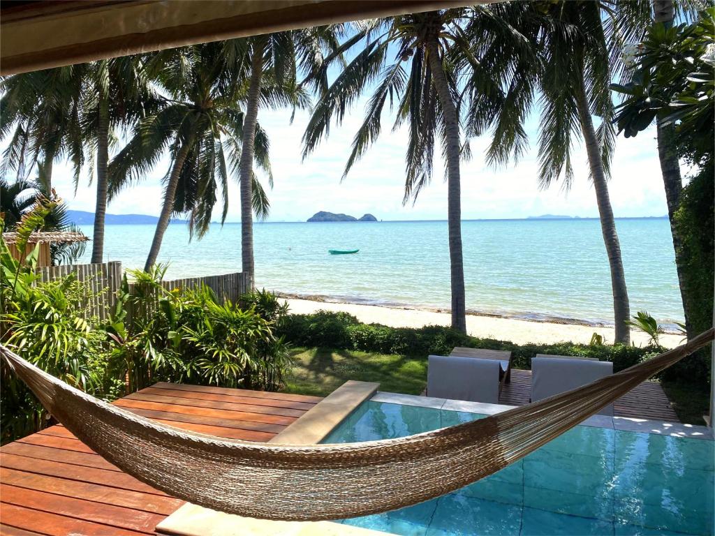 a hammock on a deck with a view of the ocean at Nibbana Bungalows in Hinkong