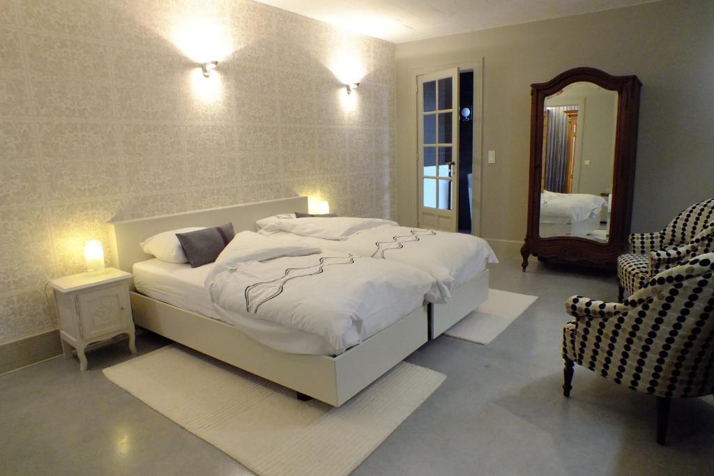 1 dormitorio con 1 cama blanca grande y espejo en B&B Sint Pieter, en Izegem