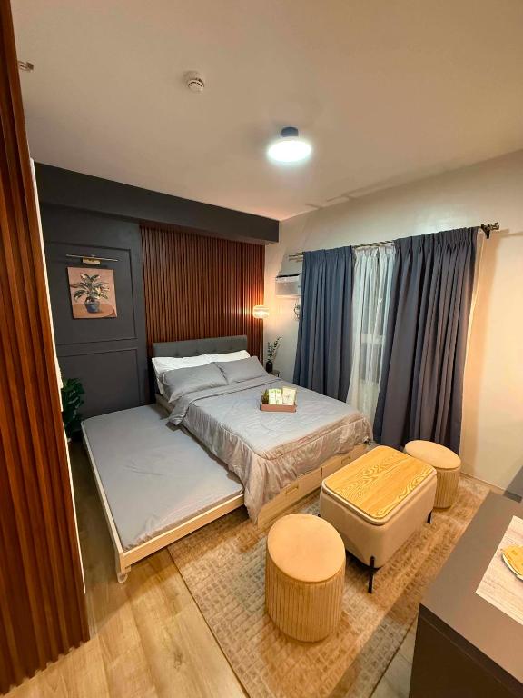 a bedroom with a bed and a table and chairs at D&J Cozy Family Studio Bacolod City in Bacolod