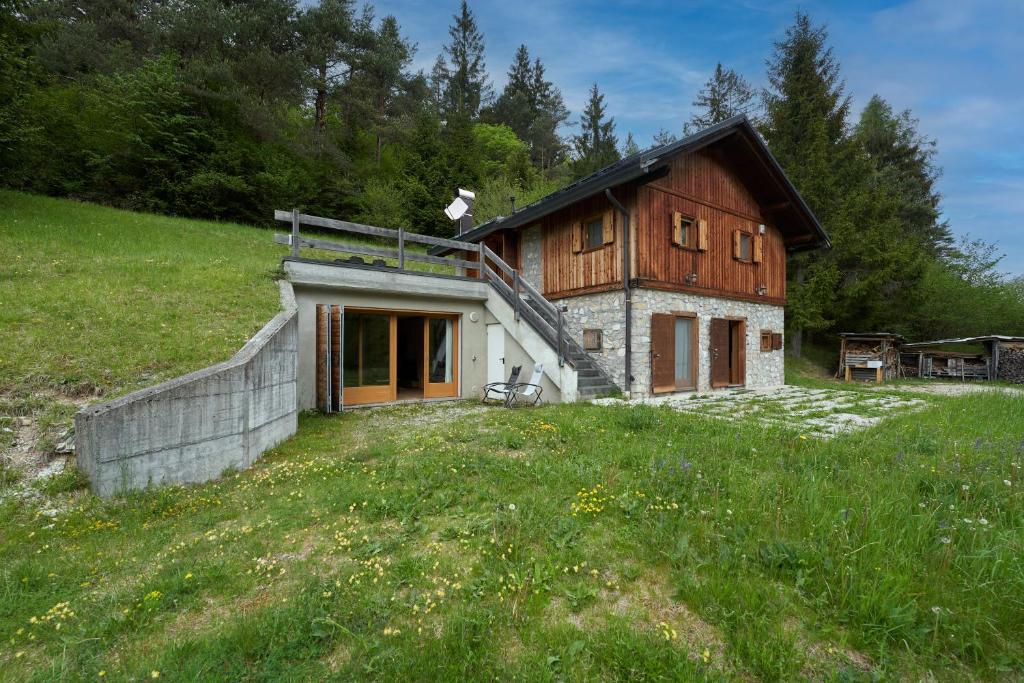a small house on a hill with a grass field at Lioda Pera Paradise in Pieve di Cadore