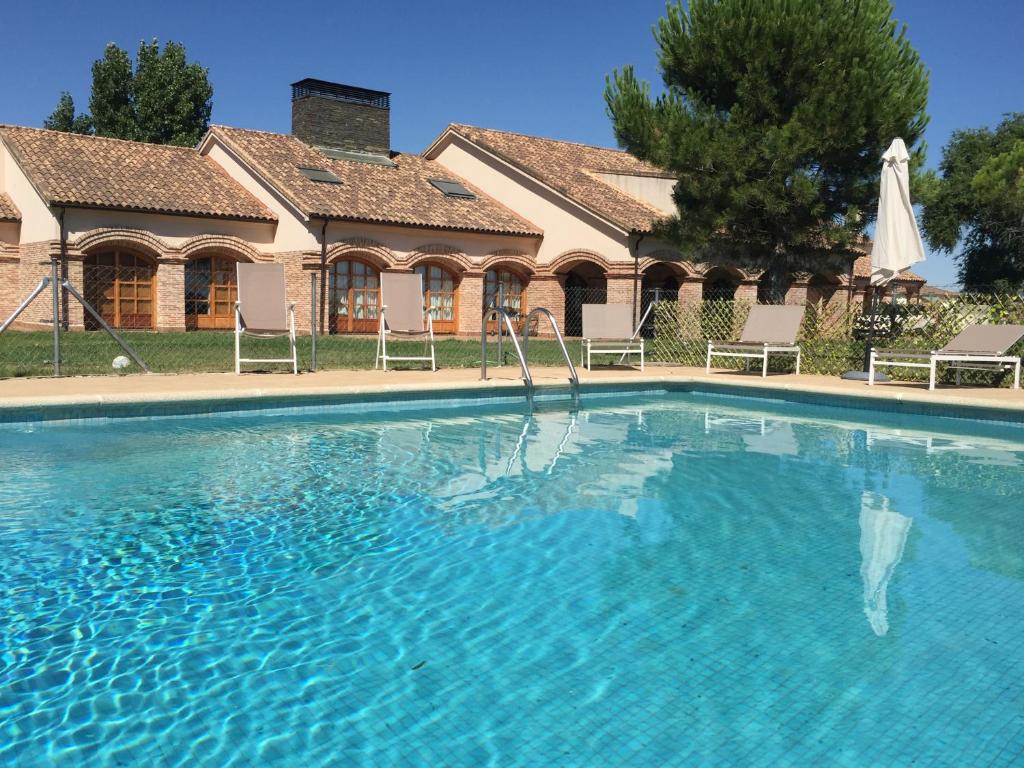 a large swimming pool in front of a house at La Casona del Tormes in Almenara de Tormes