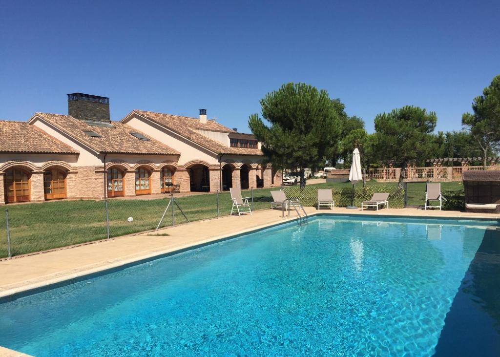 a large swimming pool in front of a house at La Casona del Tormes in Almenara de Tormes