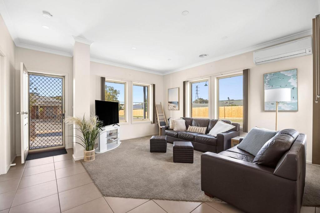 a living room with a couch and a tv at Modern home in Highton in Highton