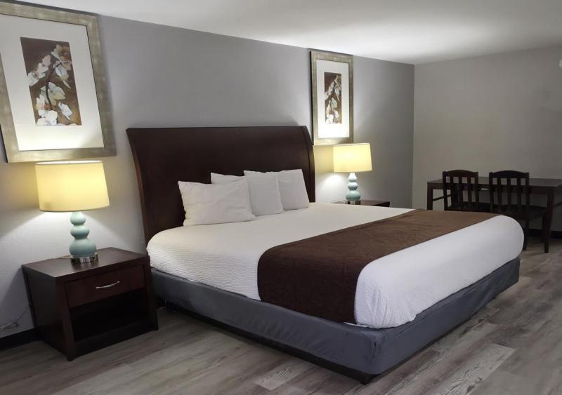 a bedroom with a large bed with two lamps at Western Inn in Forest Park