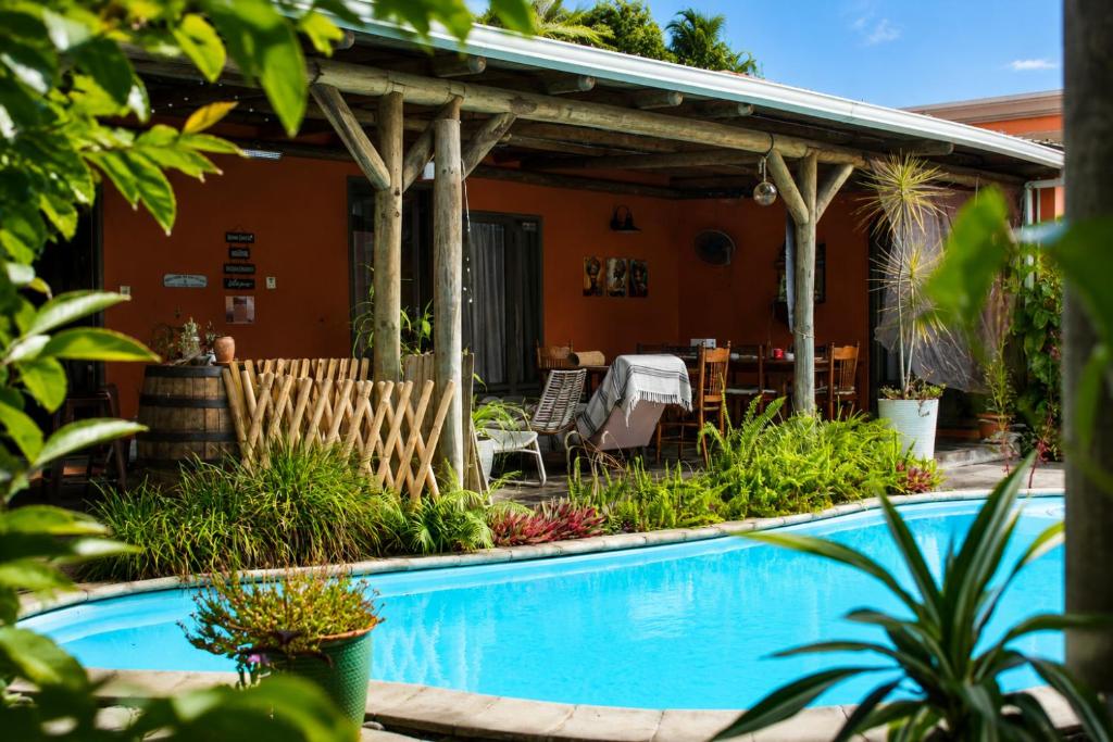 a backyard with a swimming pool and a pergola at Gite des Acacias in Union Vale