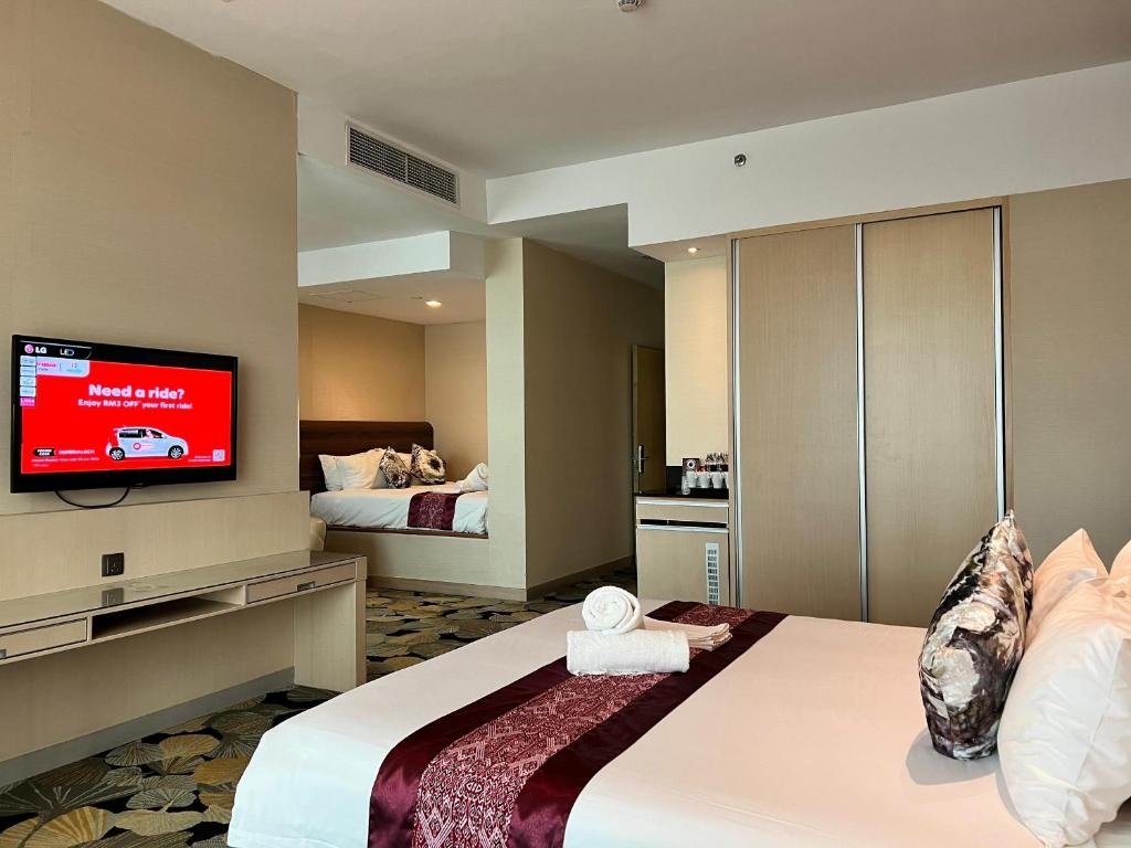 a hotel room with a bed and a flat screen tv at Imperial Hotel Kuching in Kuching