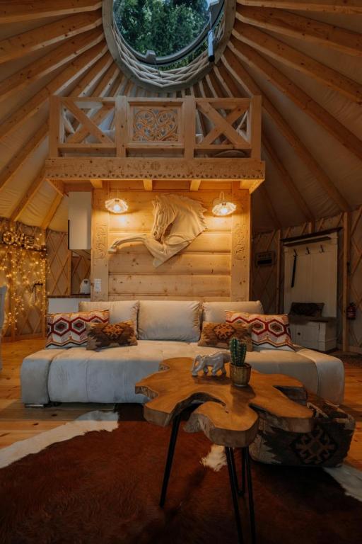 a living room with a couch and a table at Jurta na Wypasie - luksusowy namiot z widokiem na góry - Jacuzzi, Sauna, Split AC, Private, Star View in Zakopane