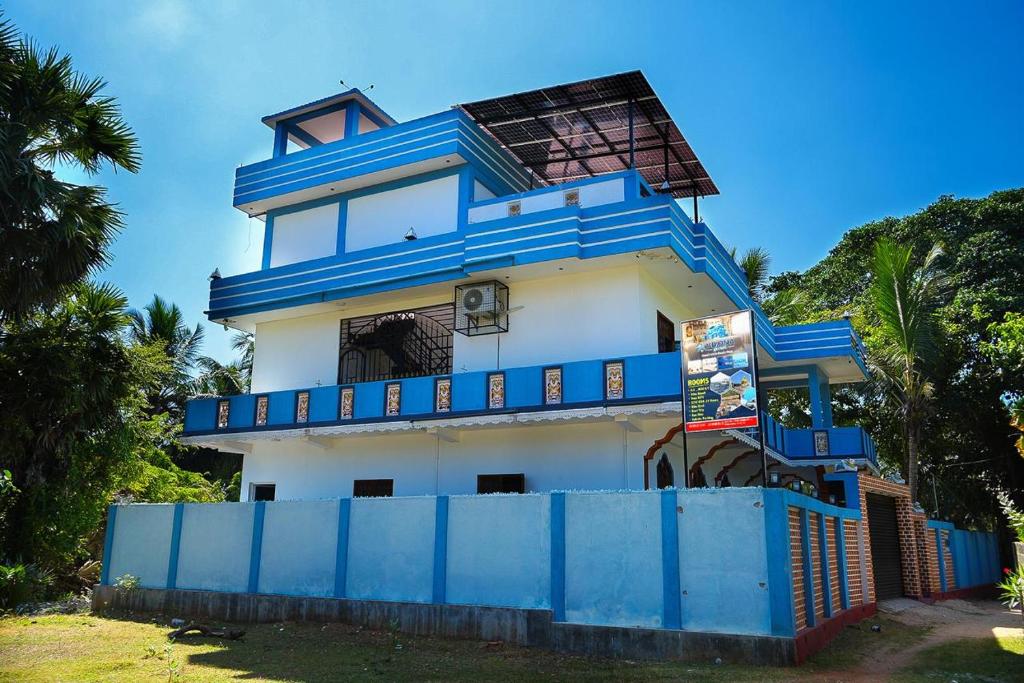 a blue and white house with a blue fence at Viyona Guest House in Trincomalee