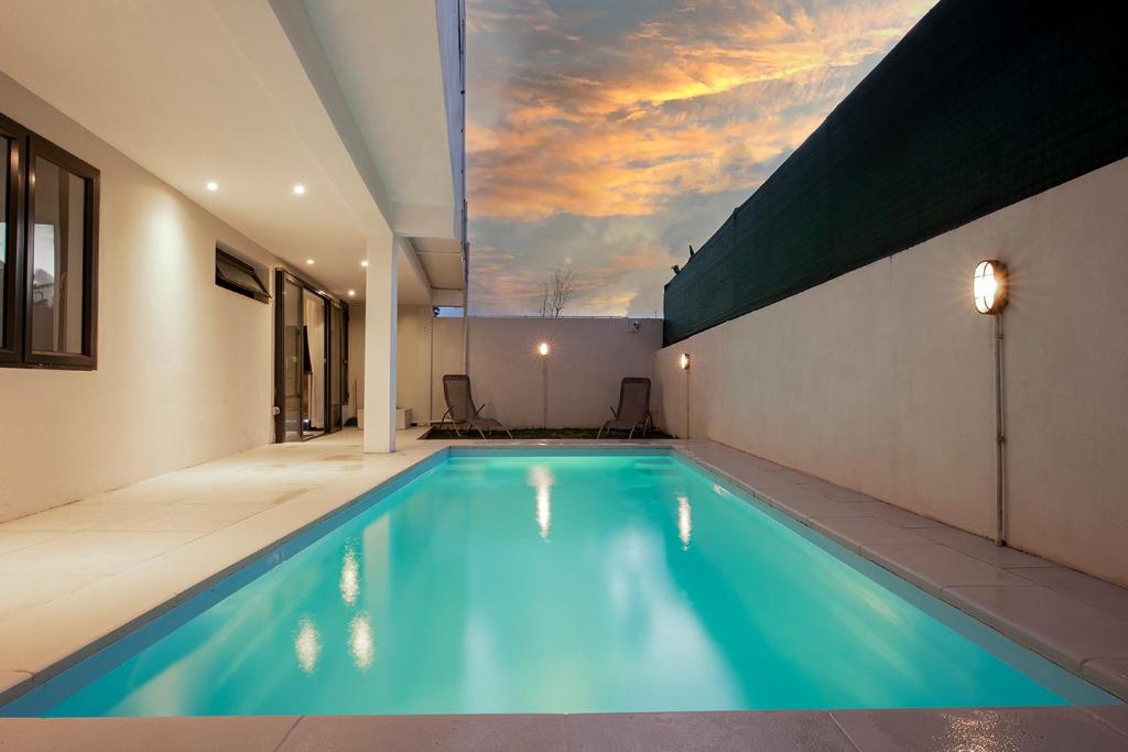 a swimming pool in a house with a sky at Villa Ptit Bouchon - En face de la Plage - Facing beach with Ocean views in Bouchon
