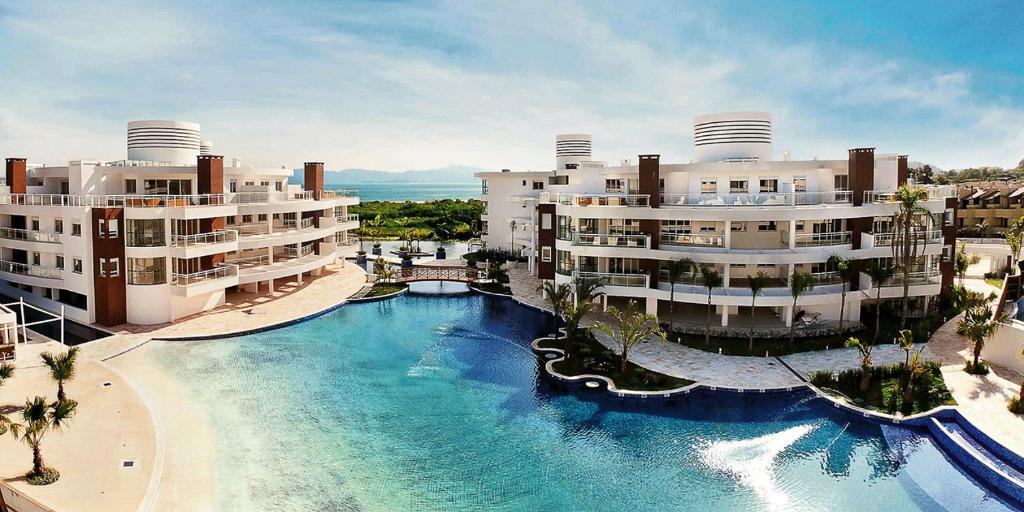 - une vue aérienne sur une piscine en face des bâtiments dans l'établissement Flat 3 suites frente mar, à Florianópolis