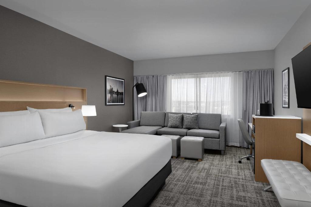 a hotel room with a large white bed and a couch at Radisson Hotel Cedar Rapids in Cedar Rapids