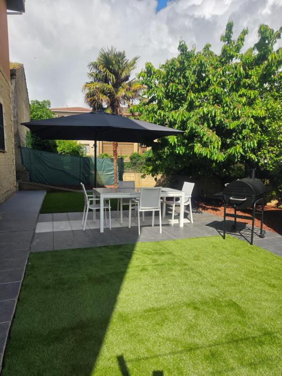 a patio with a table and chairs and an umbrella at Baketxea, 8 PAX, Jardín, BARBACOA y Merendero in Elvillar
