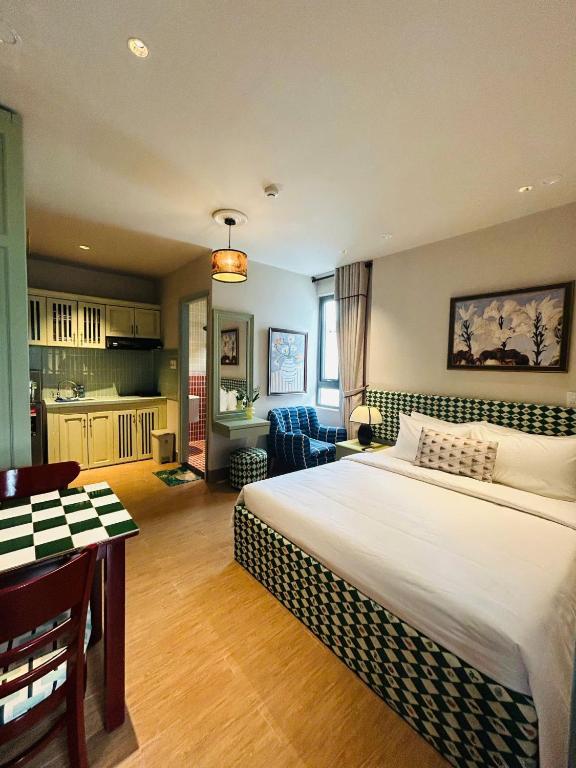 a bedroom with a large bed and a kitchen at LangX Heaven Hotel & Apartment in Danang