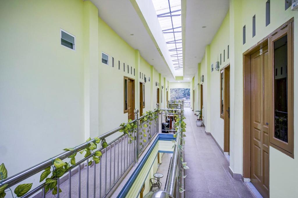 an empty hallway of a building with plants at Hotel O Balige City Near Tugu Juara Monang in Balige