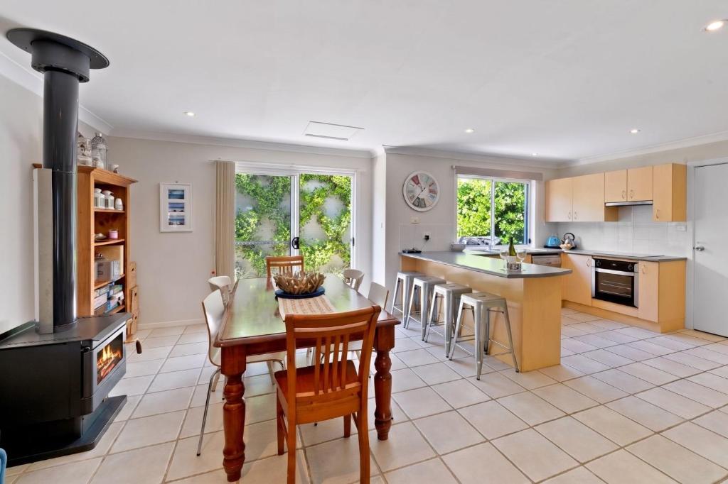 a kitchen with a table and chairs and a stove at Husky House by Experience Jervis Bay in Huskisson