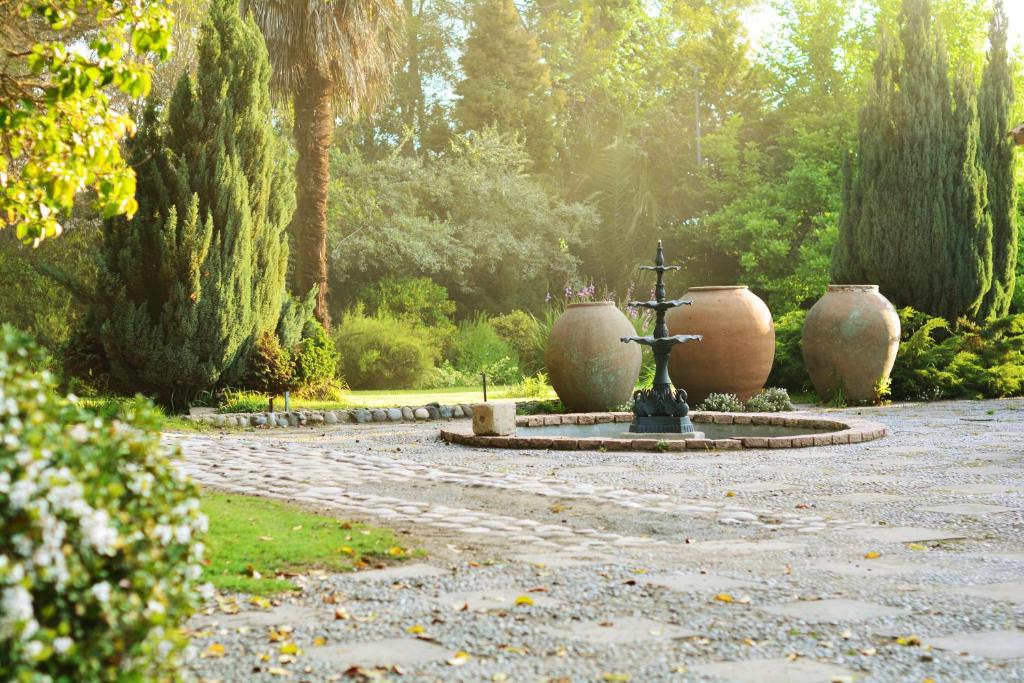 una fuente en un jardín con dos jarrones grandes en Cruz de Triana, en Rancagua