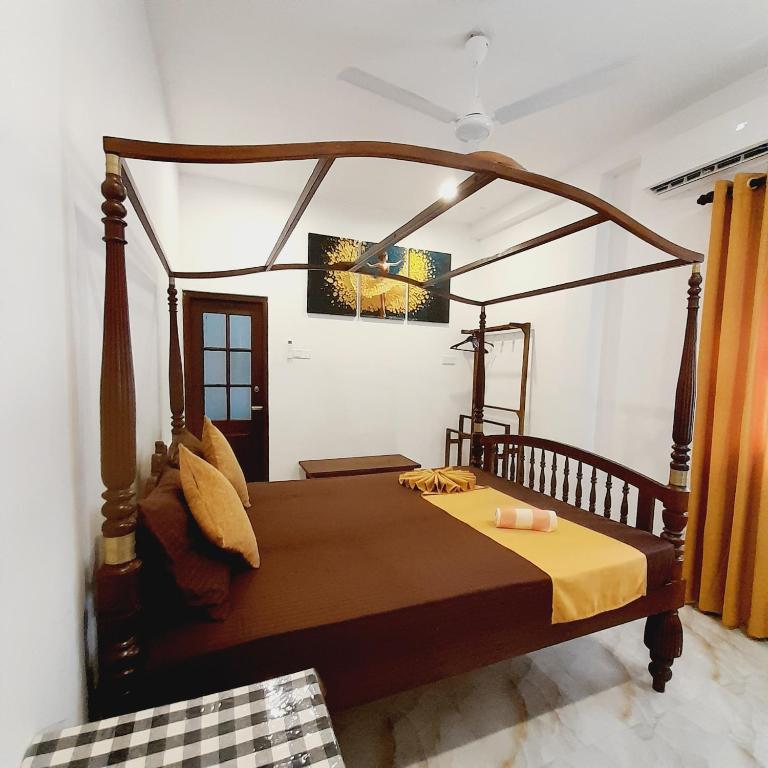 a bedroom with a wooden bed in a room at Ashan Villa Ahungalla in Ahungalla