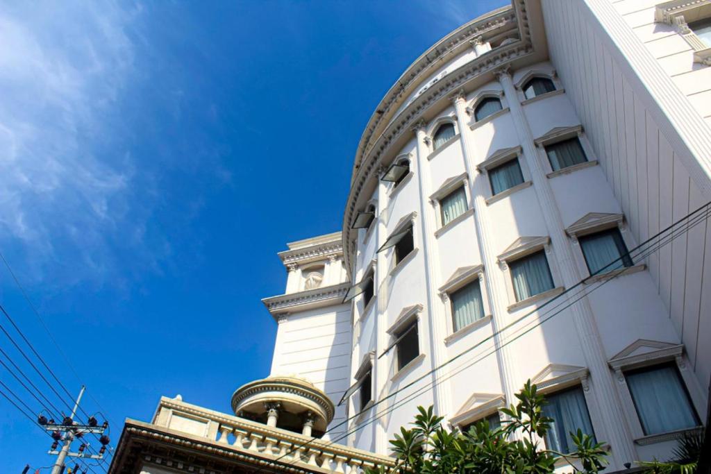 a white building with a blue sky in the background at Quds Royal Hotel in Surabaya