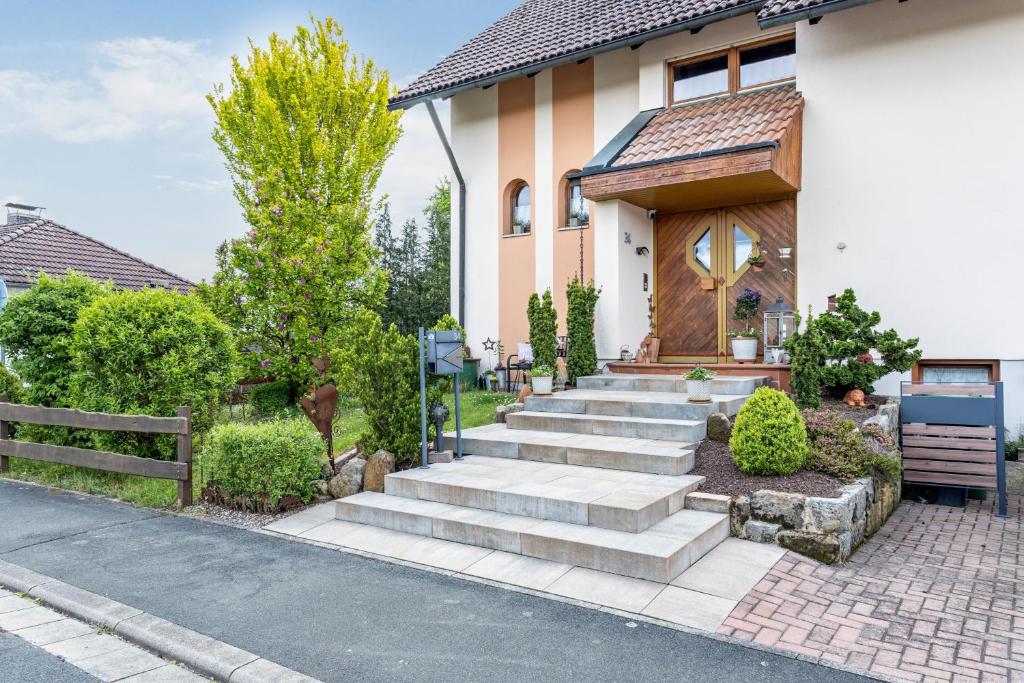 a house with stairs leading to the front door at Ruhige Einliegerwohnung mit Terasse in Altenkunstadt