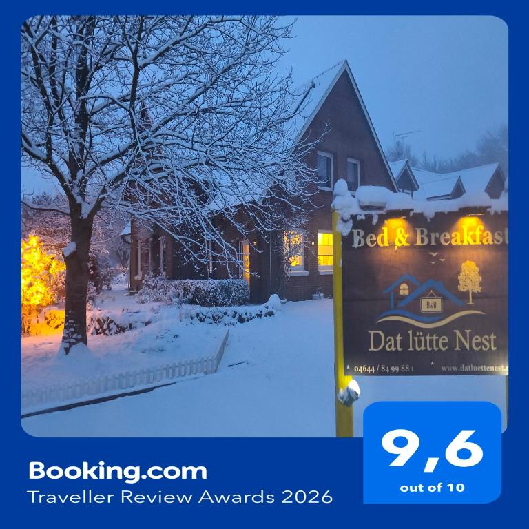 a sign in front of a house in the snow at Dat lütte Nest in Brodersby