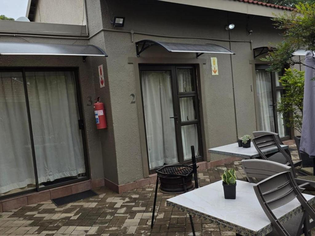 an outdoor patio with tables and chairs and a fire hydrant at Witteberg in Krugersdorp