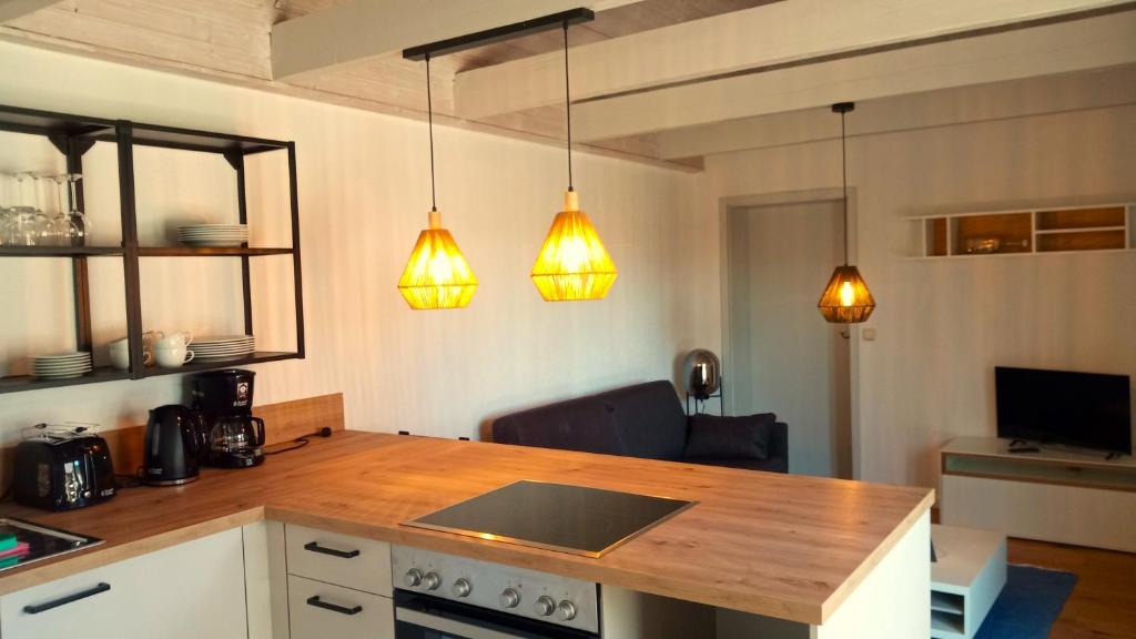 a kitchen with a wooden counter top and three lights at Fischstuebchen Neeberg in Krummin