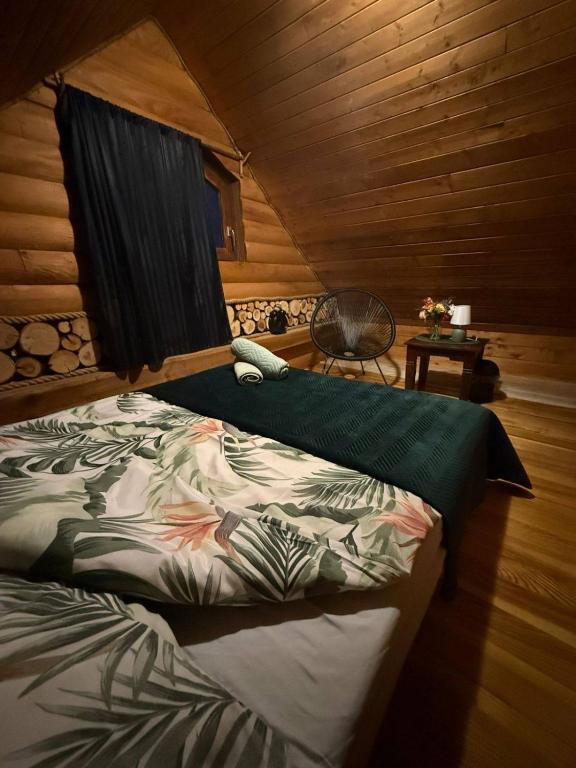 a bedroom with a bed in a wooden cabin at Pod Milanem in Przemyśl