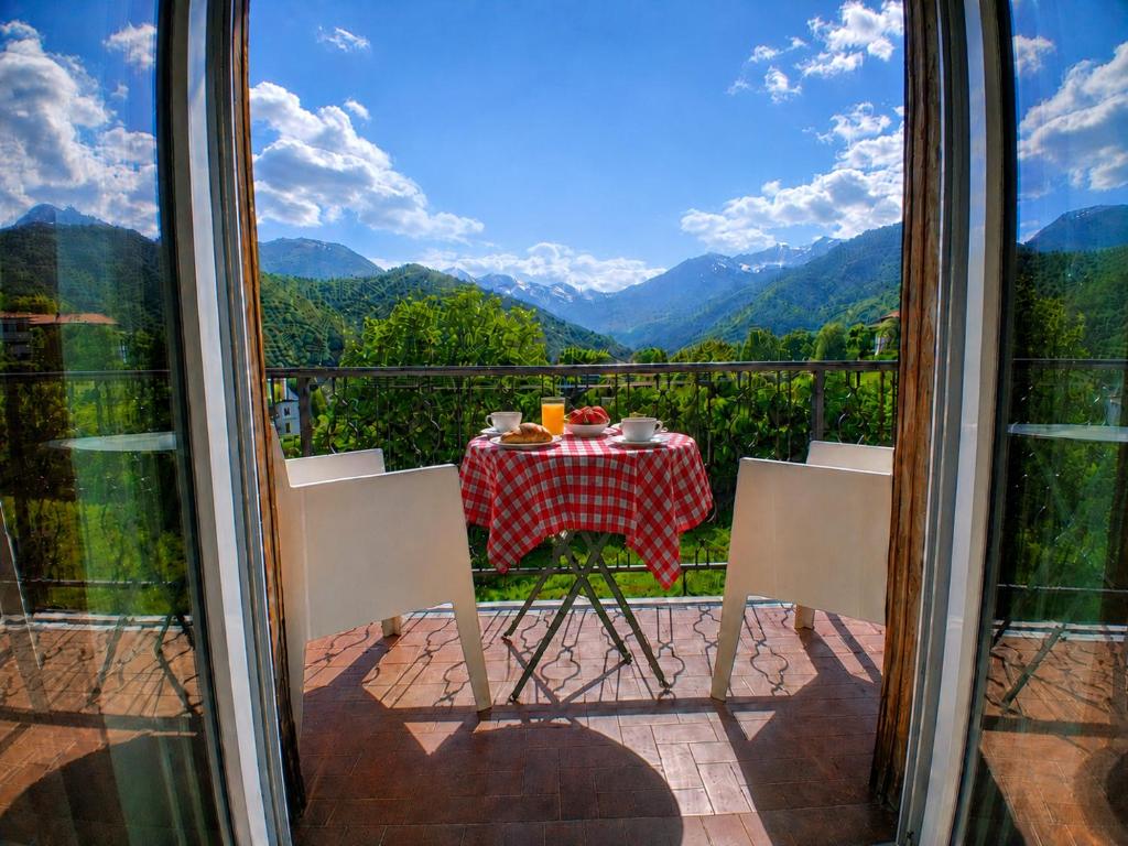 a table and chairs on a balcony with a view of mountains at Bellavista in Coazze