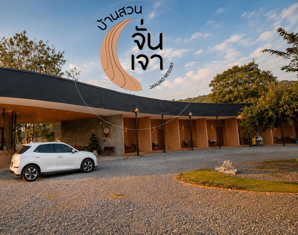 a white car parked in front of a building at JanJao Resort in Nakhon Sawan