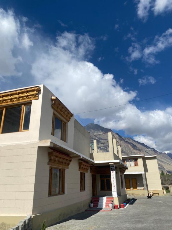 a house with mountains in the background at Tsogstot residency in Deskit
