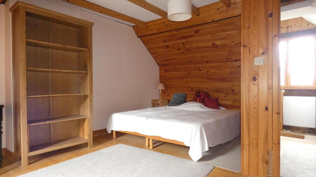 a bedroom with a bed and a wooden wall at Maison La Picade in Saint-Mamet