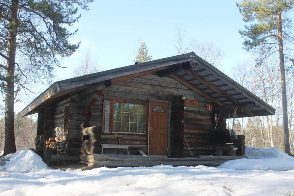 a log cabin in the snow in the woods at River Cabin Urpo in Inari