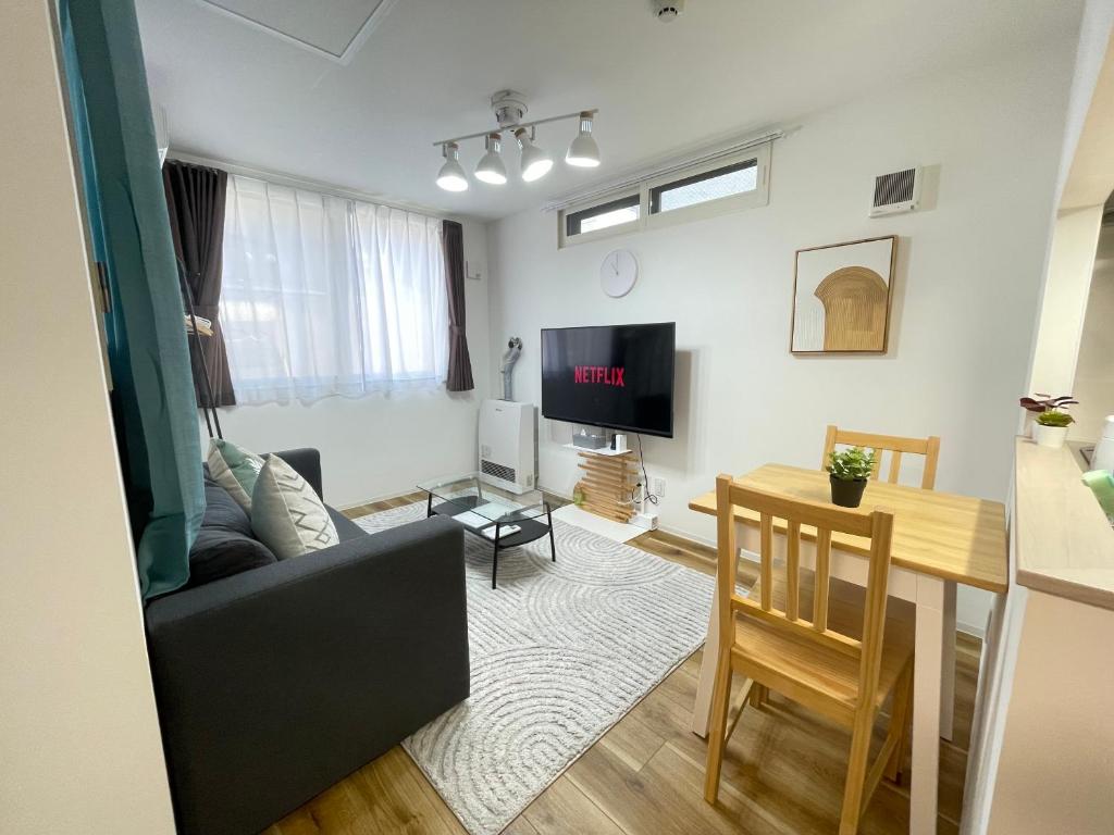a living room with a couch and a table at エムズ千歳幸町2 in Chitose