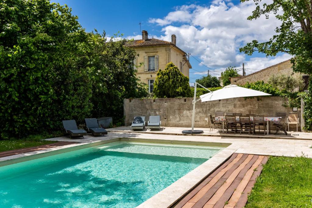 a swimming pool in front of a house at Le Loft - Château Le Noble in Saint-Germain-du-Puch